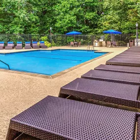 Resort style pool with sundeck for lounging and umbrellas