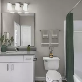 Bathroom with quartz countertop undermount sink and bathtub with curved shower rod