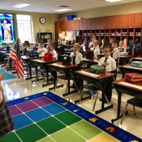 Students learning the the pledge of allegiance at an early age at Ave Maria Academy.