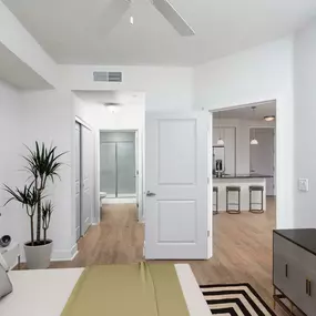 Bedroom with ensuite bath large closet ceiling fan and wood look flooring