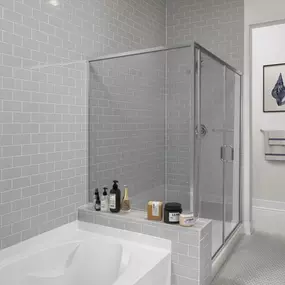 Penthouse bathroom with separate bathtub and glass enclosed shower with floor to ceiling tile