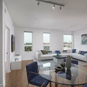 Open concept floor plan dining and living area with wood look flooring and track lighting