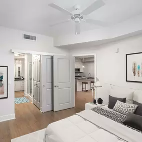 Bedroom with ceiling fan ensuite bathroom and wood look flooring