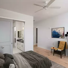 Penthouse bedroom with barn door to ensuite bathroom high ceilings and wood look flooring