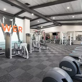 24-hour fitness center with cardio and strength training machines and dumbbells