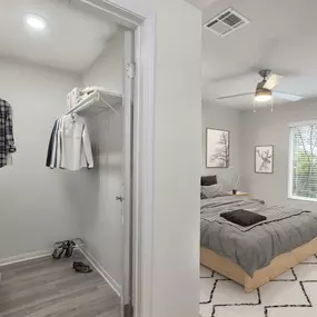 Bedroom with walk in closet wood look flooring and ceiling fan