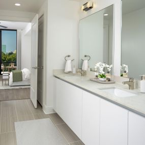 Penthouse bathroom with white quartz countertops, white, soft-close cabinetry, and tile flooring