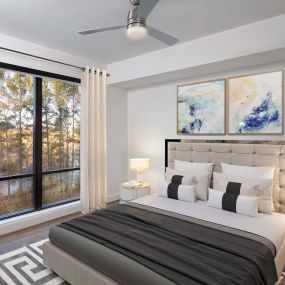 White contemporary bedroom with ceiling fan and large windows