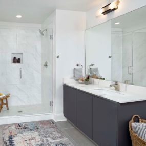 Modern gray bathroom with tile flooring and glass walk-in shower