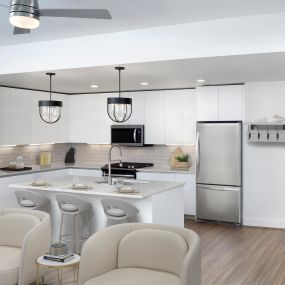 White contemporary open-concept kitchen and living room with hardwood-style flooring throughout