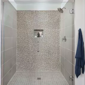 White contemporary walk-in shower with frameless glass door and geometric tile surround