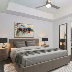 Modern gray bedroom with hardwood-style flooring, ceiling fan, and walk-in closet