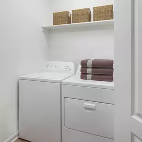 Laundry room with shelving storage at Camden Fair Lakes Apartments in Fairfax, VA.