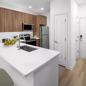 Kitchen with white quartz countertops, dulce wood shaker cabinets, and recessed lighting at Camden Fair Lakes Apartments in Fairfax, VA.