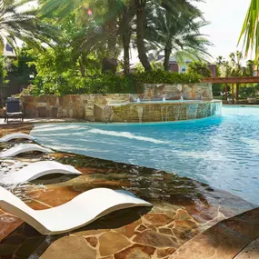 Resort style pool with tanning shelf wifi water features and grills at Camden Holly Springs Apartments in Houston, TX