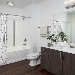 White quartz finishes bathroom with single sink vanity and bathtub