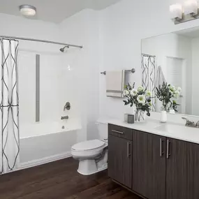 White quartz finishes bathroom with single sink vanity and bathtub