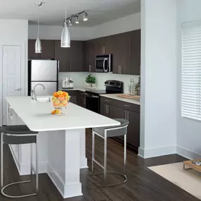 White quartz finishes in kitchen with stainless steel appliances and spacius island