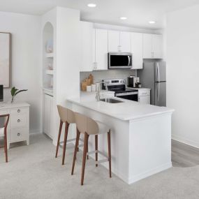 Kitchen with white finishes and home office space at Camden World Gateway apartments in Orlando, FL