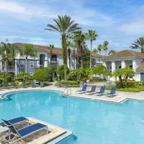 Pool surrounded by beautiful tropical landscaping at Camden World Gateway apartments in Orlando, FL