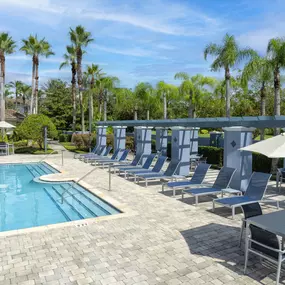 Poolside seating and lounge chairs at Camden World Gateway apartment community in Orlando, FL