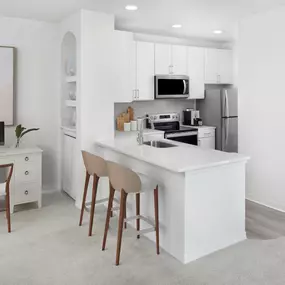 Kitchen with white finishes and home office space at Camden World Gateway apartments in Orlando, FL