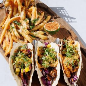 close up of fish tacos served on a platter with fries