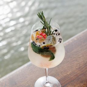 Specialty Cocktail garnished with fresh rosemary and mint