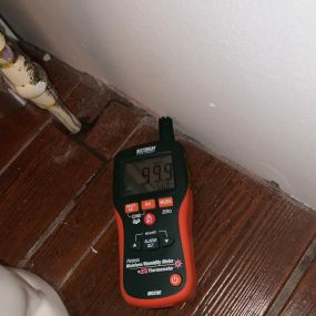 water damaged floor; moisture meter reading moisture