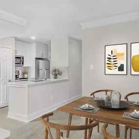 Modern Dining room and renovated kitchen with white cabinetry and white quartz countertops at Camden Fairview in Charlotte, NC