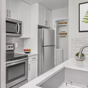 Renovated apartment homes with white quartz countertops, white shaker cabinets, and stainless steel appliances.