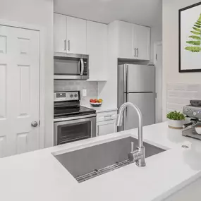 Renovated kitchen with white quarts countertops and white cabinets at Camden Fairview in Charlotte NC