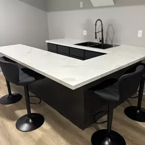 Sleek and durable, this custom epoxy countertop in Olathe, KS brings style and function together. A standout feature in this modern basement bar by Canes Exteriors.