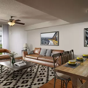 Expansive living room with lighted ceiling fan, wood-look flooring, and private patio in traditional finish style at Camden Doral apartments