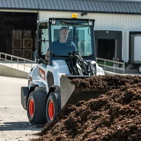 A Bobcat L23 with a Brushcat attachment