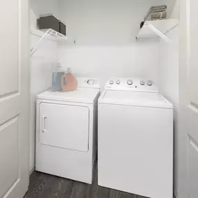 Full-sized washer and dryer closet with shelving for additional storage at Camden Potomac Yard Apartments in Arlington, VA.
