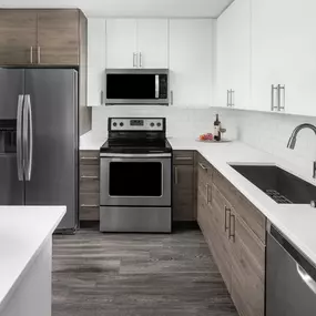 Kitchen with quartz countertop, subway tile backsplash, undermount sink, and stainless steel appliances at Camden Potomac Yard apartments in Arlington, VA
