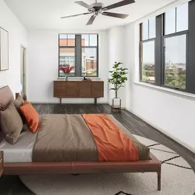 Primary bedroom in penthouse apartment home with ceiling fan, wood-look flooring, and large windows at Camden Potomac Yard Apartments in Arlington, VA