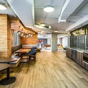 Resident lounge with a kitchenette and cafe-style seating at Camden Potomac Yard in Arlington, VA.