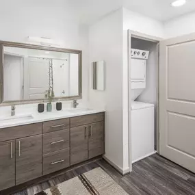 Bath with double-sink vanity and stackable washer and dryer at Camden Potomac Yard apartments in Arlington, VA