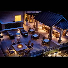 Outdoor lounge with fire pits and grills nighttime view
