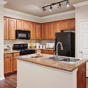 Kitchen wood like flooring and island counter at Camden Woodson Park in Houston, TX