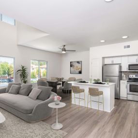 Townhome living and dining area near kitchen with stainless steel appliances, white quartz countertops, subway tile backsplash, and brushed nickel fixtures