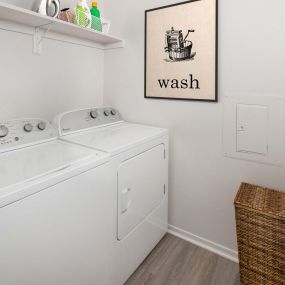 Laundry room with full size washer and dryer and wooden shelf for storage