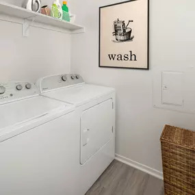 Laundry room with full size washer and dryer and wooden shelf for storage