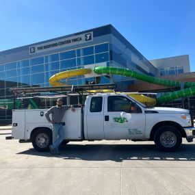 One of the Tioga Plumbing & Electric service techs with their truck in Bedford Texas at The Bedford Center YMCA.