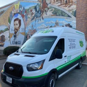 A Tioga Plumbing & Electric service van in front of the Murals of Cleburne in Wright Plaza in Cleburne Texas.