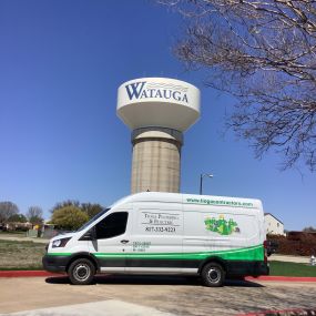 A Tioga Plumbing & Electric service van in front of one of the Watauga Texas water towers.