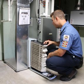 Service Tech checking a furnace filter.