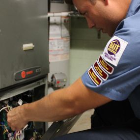 Service Tech performing a furnace inspection.